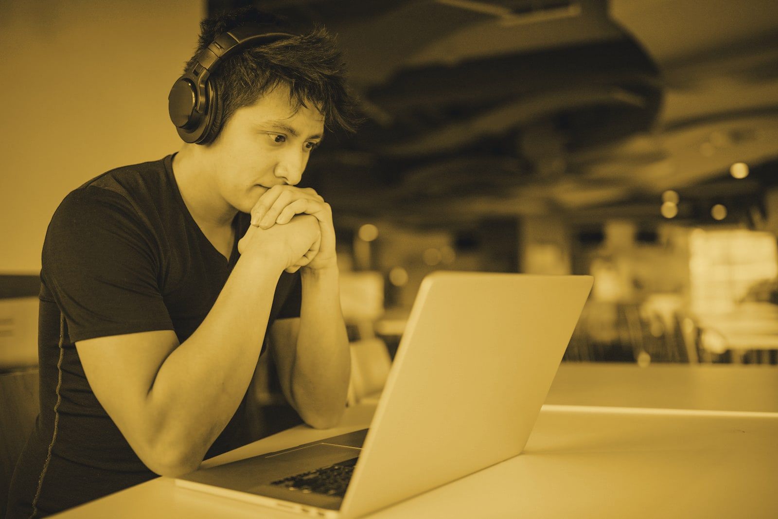 A student wearing headphones studying on a laptop