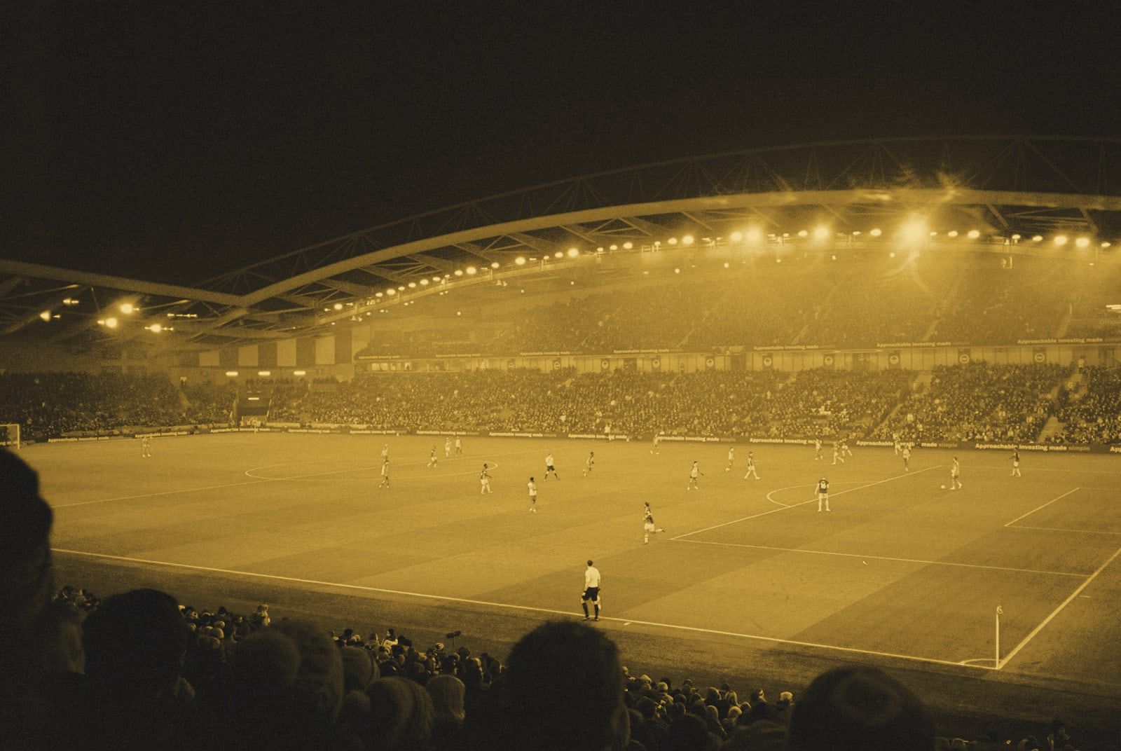 A soccer match in a floodlit stadium at night