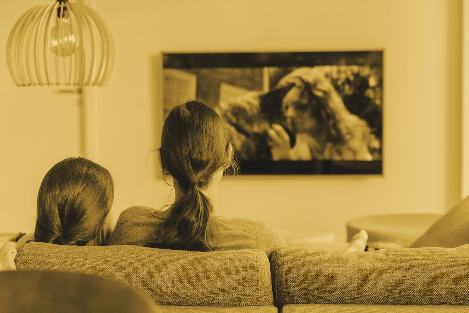Two people watching a film on a living-room TV
