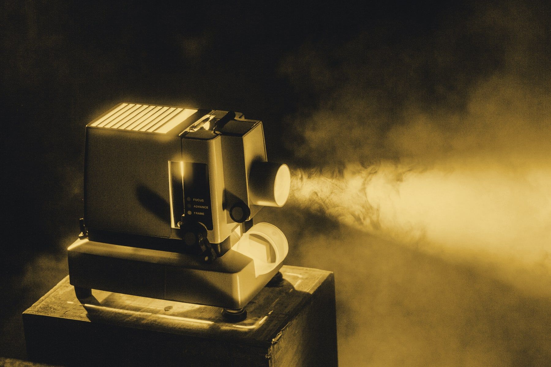 A film projector casting a beam of light in a dark room